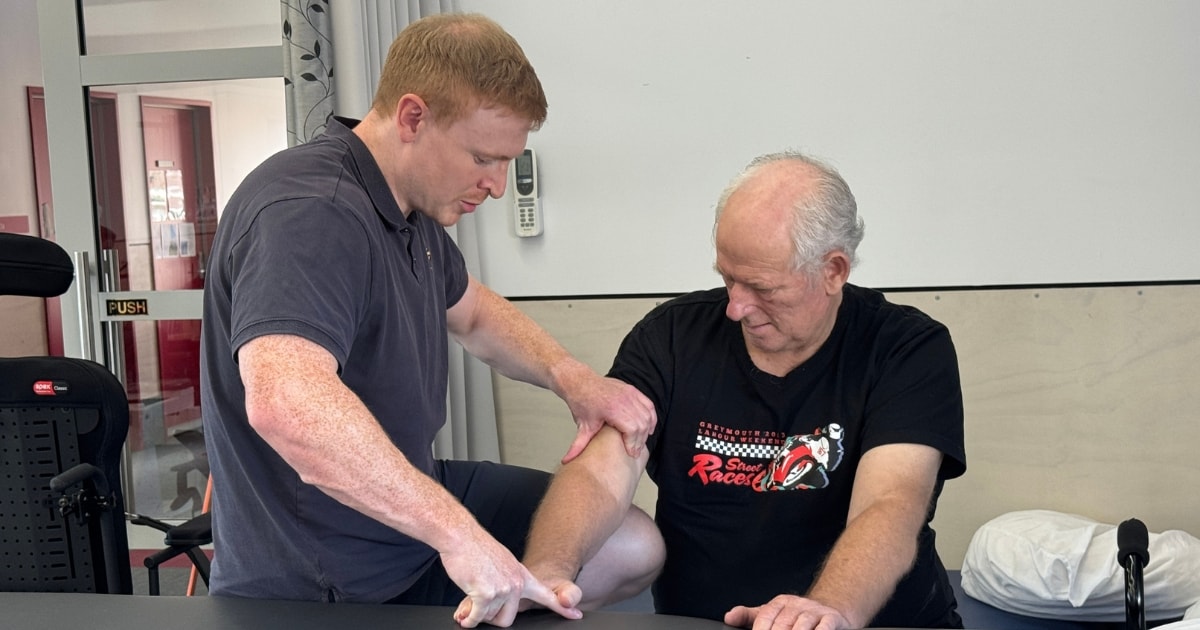 Senior physiotherapist Jake assisting a patient with their arm exercise